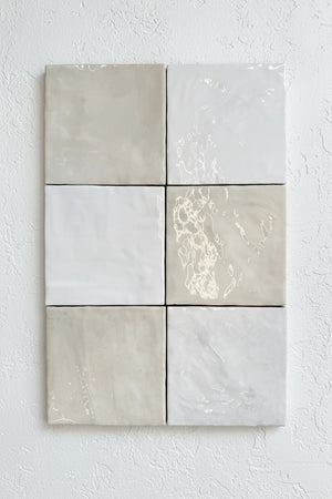 Six square tiles with gray and white marbled patterns on a stone surface.