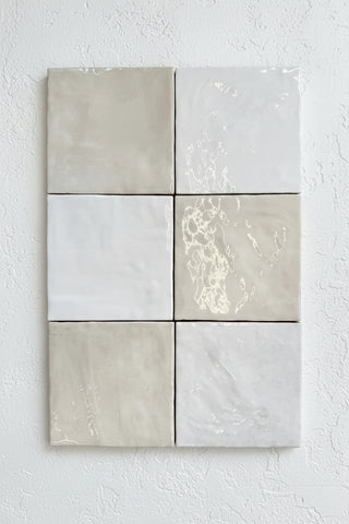 Six square tiles with gray and white marbled patterns on a stone surface.