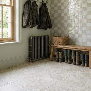 Nook with coat hooks, radiator, wooden bench and chequer tile wall.