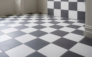 Checkered black and white tiles on a floor with a neutral-colored wall.