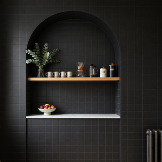 Black tiled arched feature wall with 100x100mm square black plain tiles.