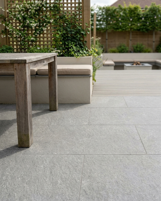 ground outdoor silver porcelain on an outdoor patio with a wooden table and bench on a tiled floor.
